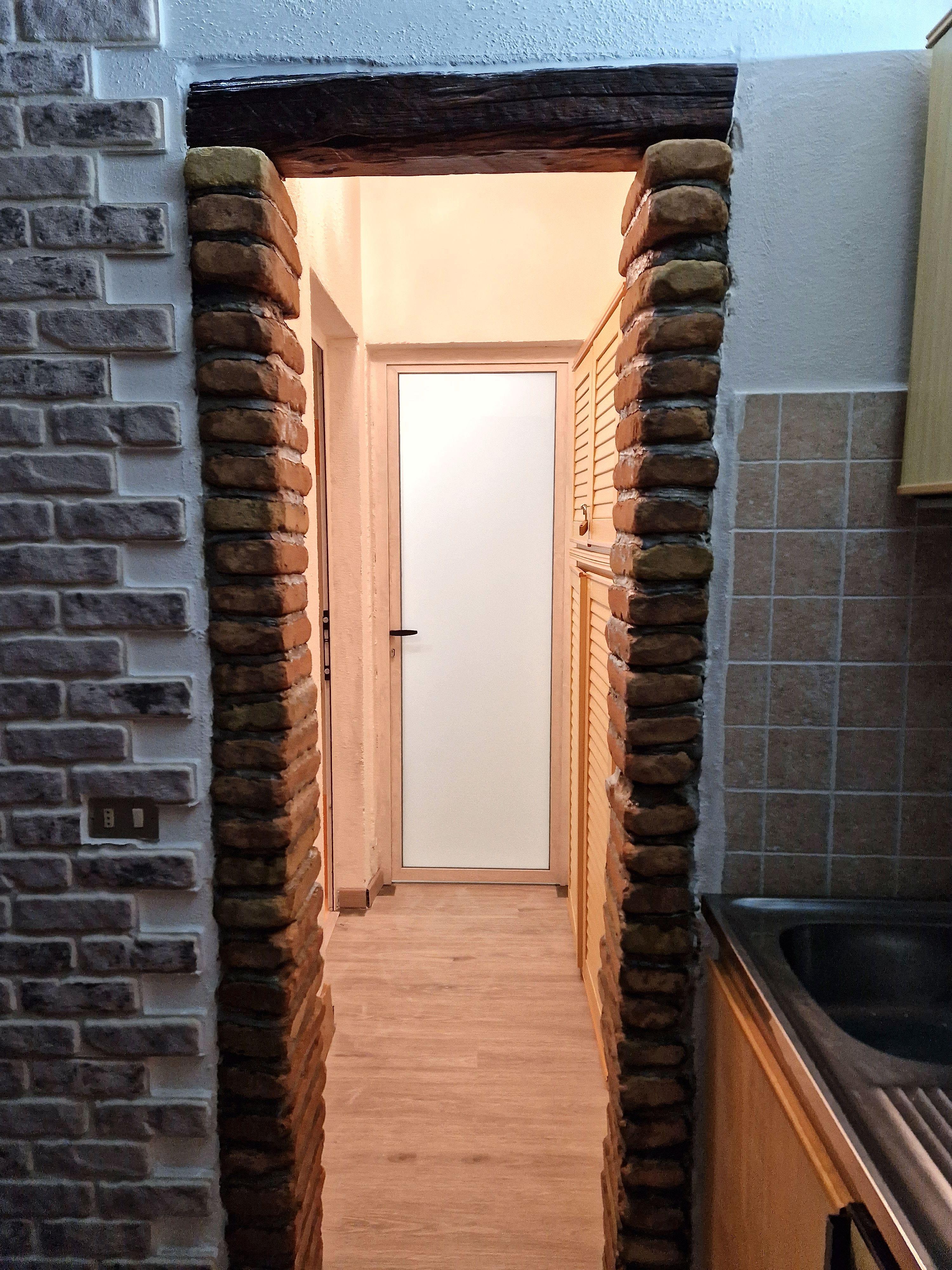 Corridoio con arco in mattoni e dettagli rustici