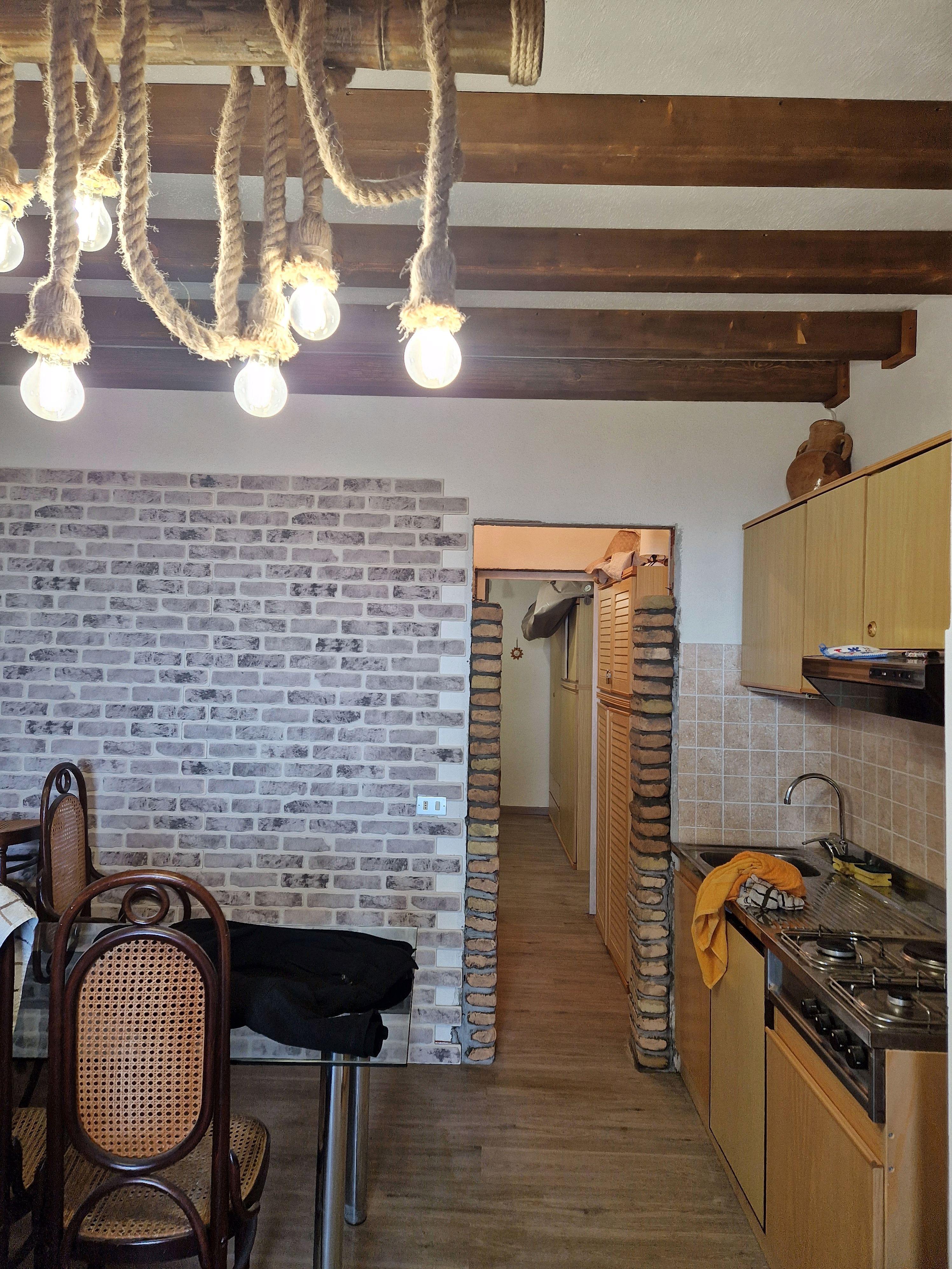 Soggiorno con travi a vista e illuminazione rustica