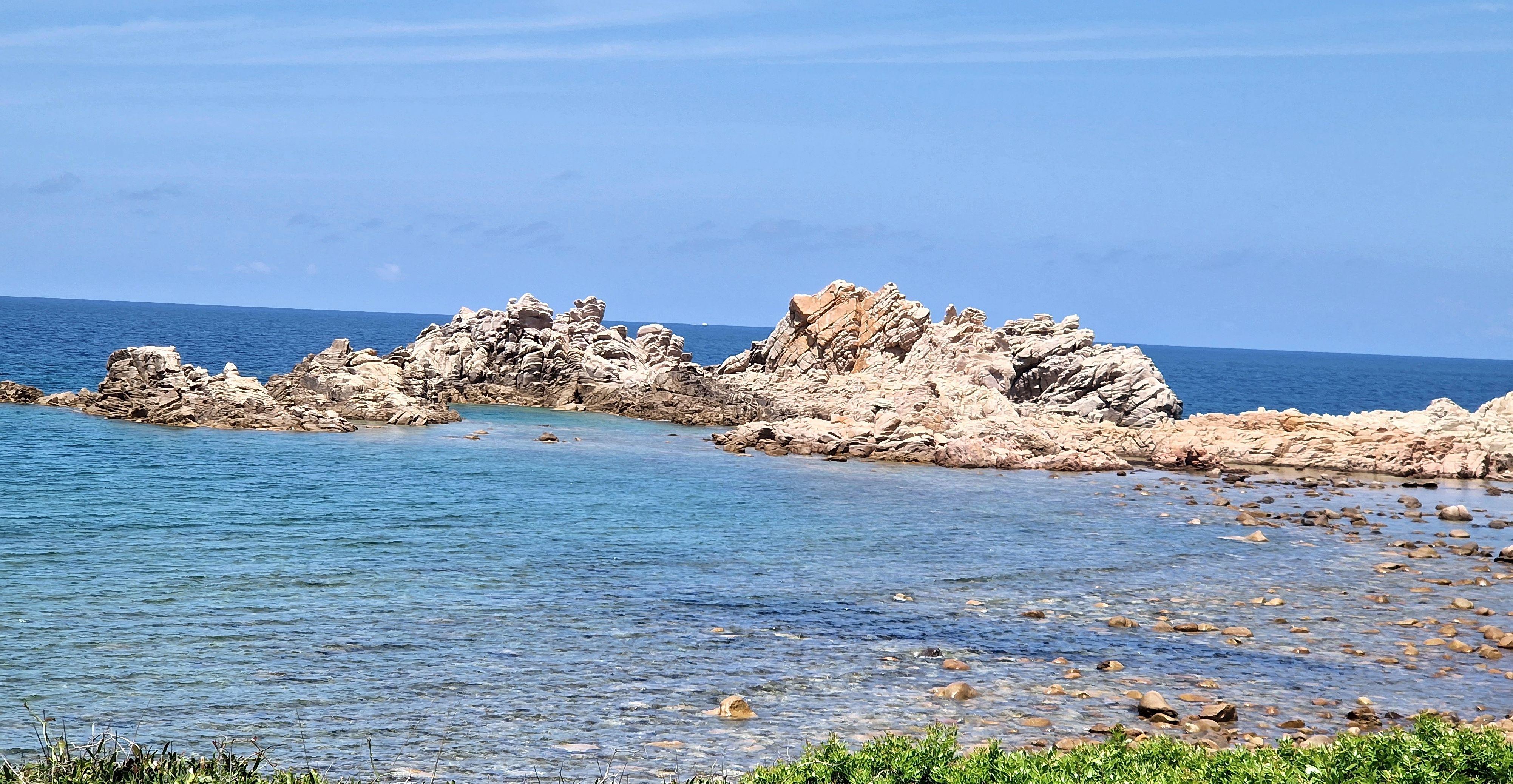 Costa rocciosa con formazioni naturali e mare turchese